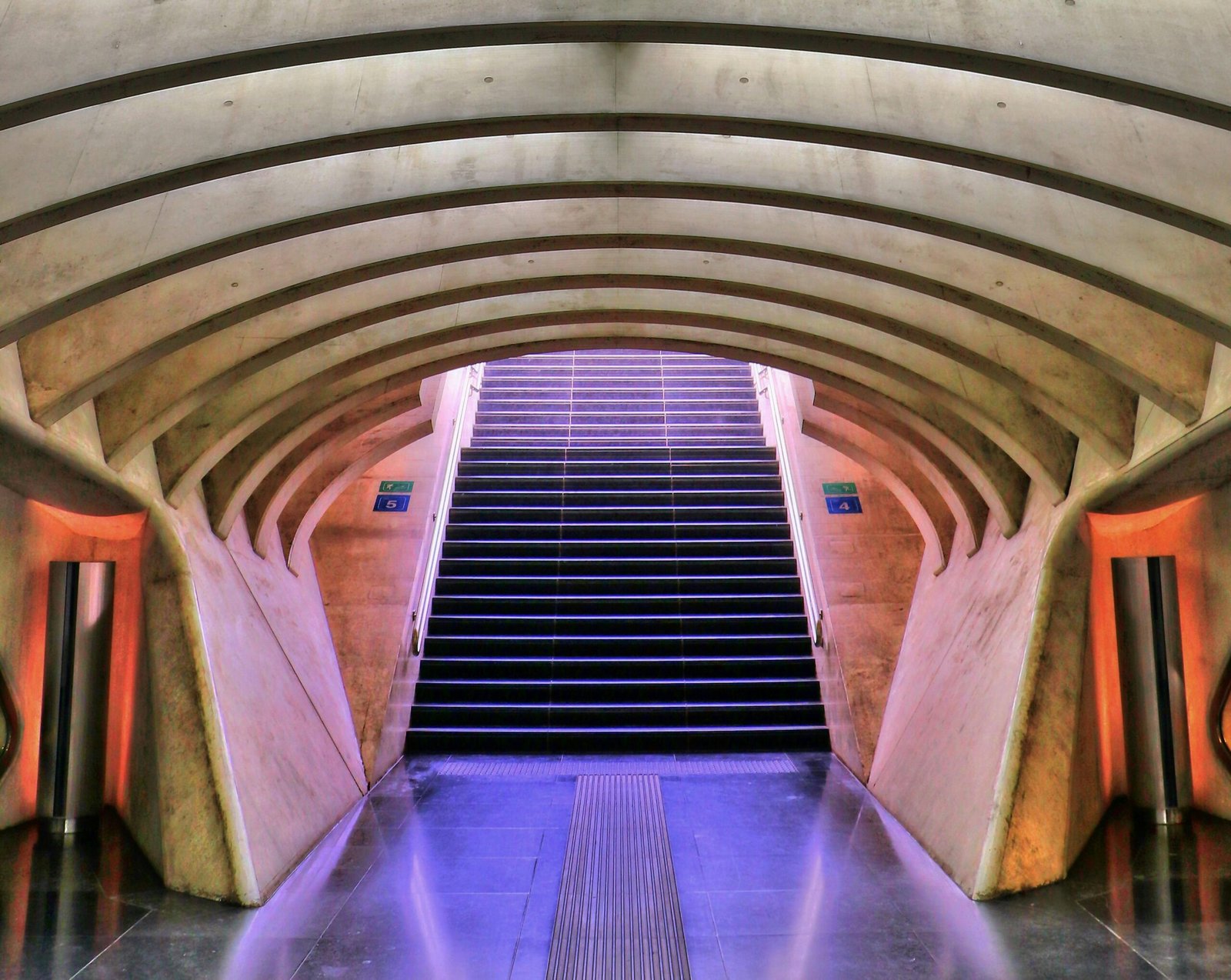 A striking perspective of modern urban architecture in a subway station stairway.