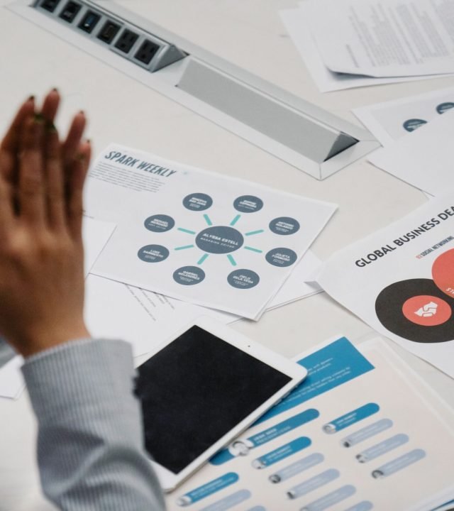 Businesswoman reviewing charts and documents during a professional meeting in an office setting.